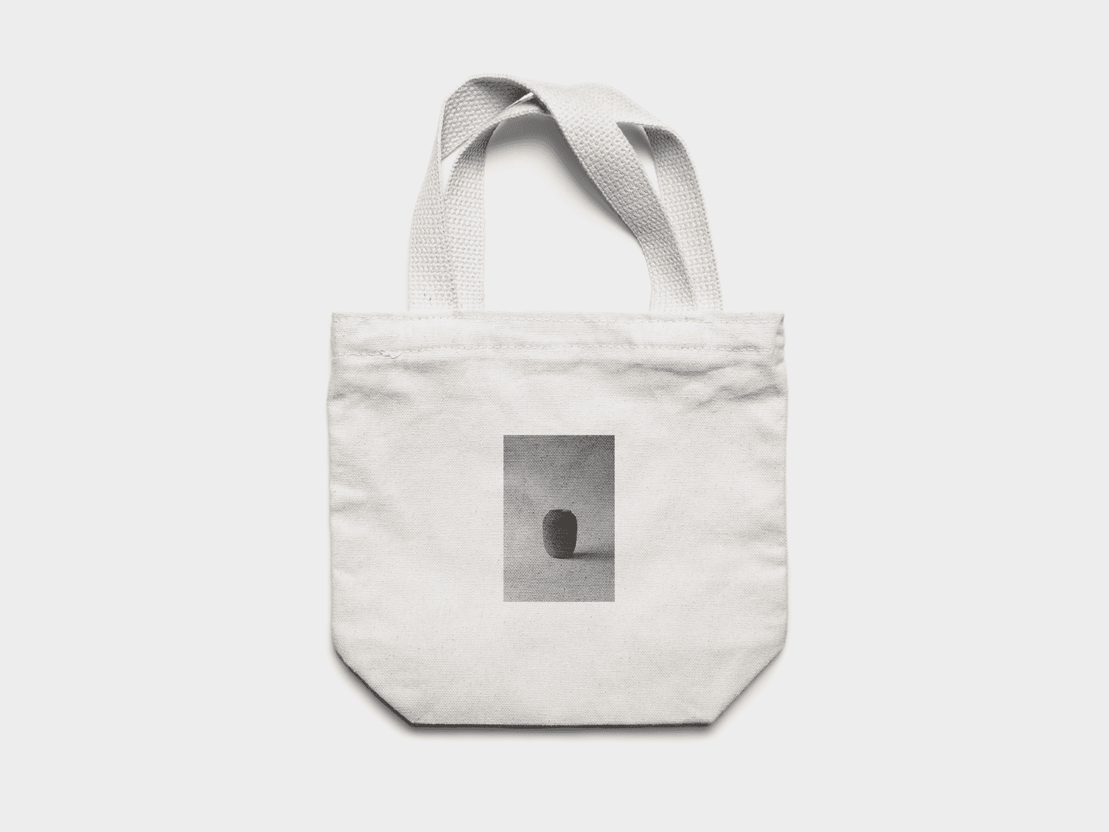 White canvas tote bag featuring a black and white image of a stoneware vase printed on the front. by Sydney SG